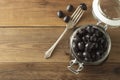 Pickled pitted black olives in glass jar, wooden background. Mediteranian foods. Copy space Royalty Free Stock Photo