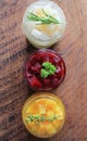 Pickled red, white, orange beet in glass jars. Variety pickles on rustic background