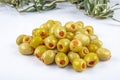 Pickled small green olives, filled with red sweet pepper in a wooden bowl. Fruits of Olea europaea, stuffed with bell pepper Royalty Free Stock Photo