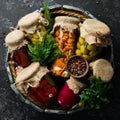 Pickled vegetables and mushrooms in glass jars in Wooden box on black stone background. Royalty Free Stock Photo