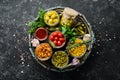 Pickled vegetables and mushrooms in glass jars in Wooden box on black stone background. Royalty Free Stock Photo