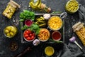 Pickled vegetables and mushrooms in glass jars in Wooden box on black stone background. Royalty Free Stock Photo