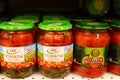 Pickles of tomatoes in banks on the shelves in the store