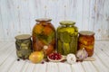 Pickles tomatoes squash pepper rolled in glass jars, onions garlic cranberries, on a wooden table light brown. Vegetables, product