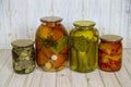 Pickles tomatoes squash peppers rolled in glass jars on a wooden table light brown. Vegetables, products