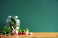 Pickling cucumbers in cans. Ingredients for marinated gherkins, glass jar, garlic, dill, salt, pepper on green Royalty Free Stock Photo