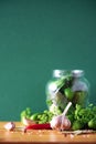 Pickling cucumbers in cans. Ingredients for marinated gherkins, glass jar, garlic, dill, salt, pepper on green Royalty Free Stock Photo