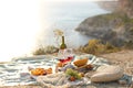 Picknick outdoors with fruits and wine by sea in naure Royalty Free Stock Photo