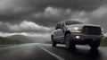 A pickup truck is driving down the road. Dark dramatic landscape as background, gloomy sky with rainy clouds, forest and hill. Royalty Free Stock Photo