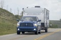 A pickup truck towing a camper RV trailer during summer time on the route Royalty Free Stock Photo