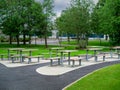 Picnic Area By Office Building For Staff Breaks Outdoors. Modern Metal Table And Seat. Green Trees And Green Grass