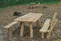 Picnic area with wooden benches and table in the middle of forest Royalty Free Stock Photo