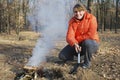 At a picnic, in the autumn forest, girl kindles a fire