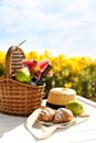 Picnic basket with bottle of wine and food on wte wooden table in lily field Royalty Free Stock Photo