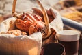 Picnic basket with bread, buns, rolls, thermoses and cups at the