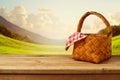 Picnic basket with checked tablecloth on wooden table Royalty Free Stock Photo