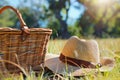 picnic basket beside a hat on sunny meadow Royalty Free Stock Photo