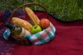 Picnic basket on the red blanket at nature. Apples, white wine a