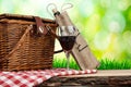 Picnic basket on the table with glass of wine Royalty Free Stock Photo