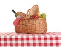 Picnic basket with wine and fruits on tablecloth Royalty Free Stock Photo