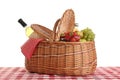 Picnic basket with wine and fruits on tablecloth Royalty Free Stock Photo