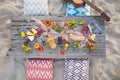 Picnic on the beach at sunset in boho style, food and drink conc