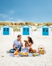 Picnic on the beach Texel Netherlands, couple having picnic on the beach of Texel with white sand and colorful house Royalty Free Stock Photo