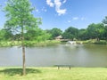 Picnic bench looking at clear pond with floating decorative water fountain at local park in Coppell, Texas, USA Royalty Free Stock Photo