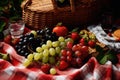 a picnic blanket covered with a basket, grapes, and strawberries