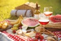 Picnic blanket with delicious food and drinks outdoors on sunny day Royalty Free Stock Photo
