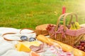 Picnic, camping basket, wine, glasses and fruits, family picnic background with space. Summer and mood. Weekend and vacation,