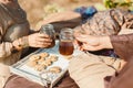Picnic of couple in clothes made of natural materials, linen, beige, brown tones. Tea drinking, Indian culture, early morning.