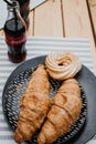 Picnic with croissants and Coca Cola on a wooden table at the camping