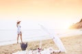 Picnic on a deserted beach and the silhouette of a girl walking along the shore. Vintage retro photo. Royalty Free Stock Photo