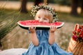 picnic with family. cute little girl eating big piece of watermelon on straw stack in summertime in the park. Adorable Royalty Free Stock Photo