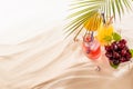 Picnic with food and drink on tropical beach, vacation background - fresh cold drinks with straw in glass bottles, green palm leaf Royalty Free Stock Photo