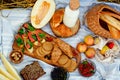 Picnic on the grain field. A natural snack, grain bread with salmon, berries and melon on a wooden board and a blanket in the