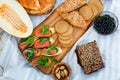 Picnic on the grain field. A natural snack, grain bread with salmon, berries and melon on a wooden board and a blanket in the