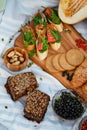 Picnic on the grain field. A natural snack, grain bread with salmon, berries and melon on a wooden board and a blanket in the