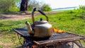 A picnic, heating water in a kettle over a wood fire