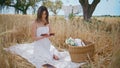 Picnic model riffling novel pages in summer field. Woman reading book at nature