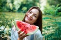 Picnic in nature and healthy eating. A sexy girl in the woods eats watermelon Royalty Free Stock Photo