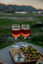 Picnic in nature with wine, cheese plate, grapes with mountains and sunset in the background Royalty Free Stock Photo