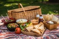 picnic in the park with picnic basket filled with tacos, burritos, and nachos