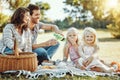 Picnic, park and and family of parents, children and happy people on garden grass in sunshine. Kids, mom and dad smile