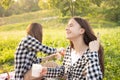 Picnic in the Park on the grass. Two young girls on a picnic eating, drinking lemonade, having fun, laughing, talking Royalty Free Stock Photo