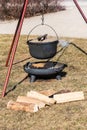 Picnic place with a campfire, firewood and boiler with lid in sunny spring day