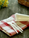 Picnic, plastic dishware and napkin on wooden