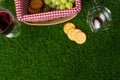 Picnic and relaxation, picnic basket, glass with red wine and grapes and snacks. Top view on the grass with space for advertising Royalty Free Stock Photo