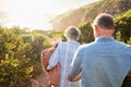 Picnic, romance and senior couple walking in nature with blanket and flowers for love and valentines day. Mountain path Royalty Free Stock Photo